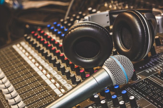 Close up instruments music background concept.Single microphone with headphones on sound mixer board in home recording studio.Free space for creative design text & wording mock up template.